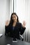 Smiling businesswoman and waving her hand to greeting her colleagues in office.