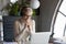 Smiling businesswoman wearing headset consulting client online in office