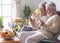 Smiling and carefree retired couple relaxing at home on the sofa looking together at smartphone. Senior people enjoying wireless