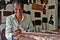 A smiling carpenter working at his own shop next to the Lankatilaka Vihara