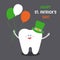 Smiling cartoon tooth in Saint Patrick`s green hat with balloons colors of the Irish flag.