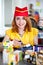 Smiling cashier girl in red and yellow uniform