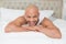 Smiling casual bald young man lying in bed