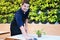 Smiling Caucasian barista young man is wearing Apron cleaning on top coffee table  in coffee shop and cafe. Start up business