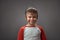 Smiling Caucasian boy with face mask wearing at his head. Happy Little boy posing on grey background.