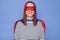 Smiling Caucasian brown haired woman wearing superhero costume and striped shirt isolated over blue background expressing positive