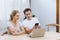 Smiling caucasian couple using smartphone for webinar or online shopping, surfing social media at home. Happy lover working