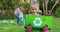 Smiling caucasian daughter outdoors holding recycling crate, collecting plastic waste with parents