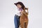 Smiling Caucasian Girl in Cowgirl Clothing Posing With Symbolic Plush Horse Against White.