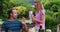 Smiling caucasian girl showing parents her top mark on school work in garden