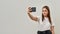 Smiling caucasian girl taking selfie on smartphone