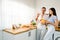 A smiling Caucasian happy couple stands in the kitchen holding a bowl with lots of fresh fruits and picks for eat. A Couple enjoys