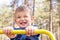 Smiling caucasian male child holding a yellow object in the park