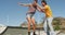 Smiling caucasian man teaching woman how to skateboard on sunny day