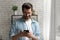 Smiling Caucasian man using smartphone at home