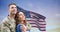 Smiling caucasian mid adult male soldier with caucasian young wife against us flag during sunset