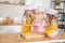 Smiling caucasian mom teaching daughters to roll out dough with rolling pin