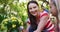 Smiling caucasian mother and daughter gardening, talking and holding yellow flowers