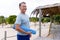 Smiling caucasian senior man with blue exercise mat looking away at tourist resort