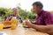 Smiling caucasian senior man holding hamburger eating meal with wife in garden