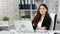 Smiling caucasian stylish businesswoman posing at workplace looking at camera medium shot