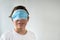 Smiling Caucasian teenager pulls his protective medical face mask up, covering his eyes instead of nose and mouse. Wrong