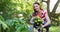 Smiling caucasian woman gardening, in garden planting yellow flowers