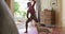 Smiling caucasian woman practicing yoga with her pet dog at home