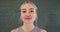 Smiling caucasian young woman with blonde hair against grey brick wall in yoga studio