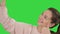 Smiling cheerful blond-haired woman doing selfie on a Green Screen, Chroma Key.