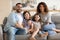 Smiling cheerful spouses posing for photo with children.