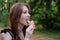 Smiling cheerful ukrainian brunette young woman eating ice cream outdoors