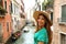 Smiling cheerful woman with hat and green dress in her venetian holidays. Happy attractive girl smile at camera in Venice, Italy.