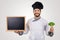 Smiling chef with blank blackboard and broccoli in hand