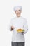 Smiling chef showing and holding a plate of prepared food, studio shot, portrait