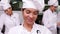 Smiling chef whisking eggs in a bowl