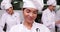 Smiling chef whisking eggs in a bowl