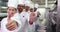 Smiling chefs standing in a row giving thumbs up