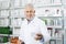 Smiling Chemist Holding Medicine At Counter In Pharmacy