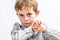 Smiling child with blue eyes looking determined, holding his fists