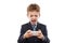 Smiling child boy in business suit playing games or surfing internet on smartphone computer