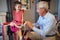 Smiling child and her grandfather choosing bicycle in bike shop