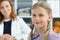 Smiling child holding stethoscope tool, professional pediatrician woman posing on background