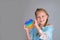 Smiling child looking at the camera and holding a rainbow pop it fidget toy heart shaped. Push bubble fidget sensory toy -