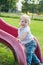 Smiling child playing on a baby slide