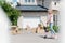 smiling child riding on kick scooter near boxes and acoustic guitar in front of new