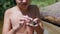 Smiling Child Strokes a Green Frog a Wet Hand on Background of the Coast River