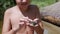 Smiling Child Strokes a Green Frog a Wet Hand on Background of the Coast River