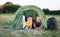 Smiling children lying in the tent in the park. Camping, tourism and teenagers activity or leisure concept