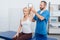 smiling chiropractor stretching womans arm on massage table